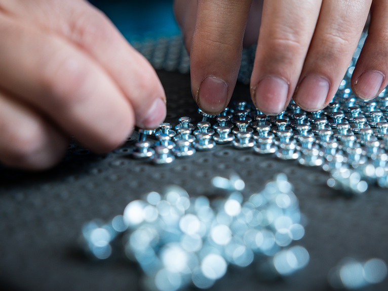 Manuelles Einsetzen kleiner Metallteile in eine Aufnahme